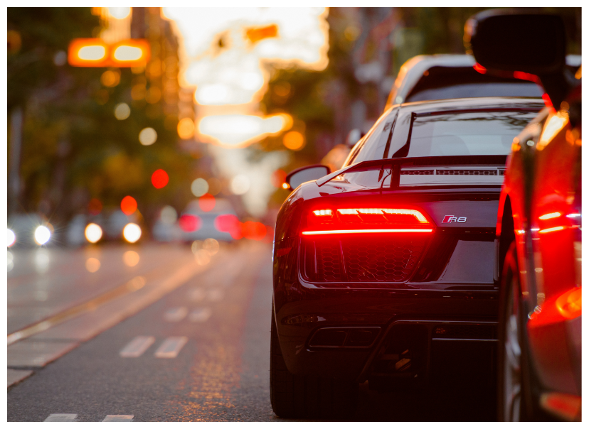 Black Audi R8 sports car parked on a city street at sunset, showcasing its distinctive rear lights and sleek design, symbolizing luxury auto repair services offered by Fairfax Circle Auto.